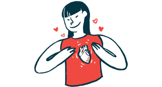 A woman smiles while gesturing to an heart pictured on her shirt.