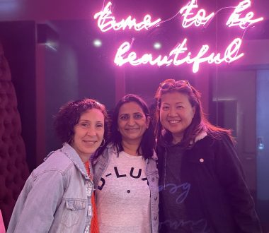 true friend | Amyloidosis News Today | Jaime and two of her friends smile for a photo at a hotel, where they're posing under a pink neon sign that reads, "time to be beautiful."