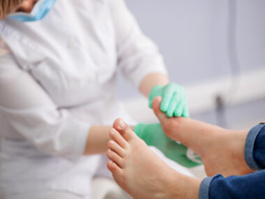 A doctor examining a person's feet
