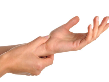 one hand holding the other's wrist as if in pain