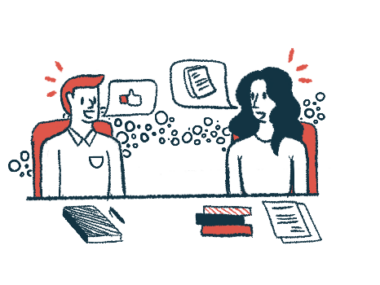 Two people sit at a table sharing ideas.